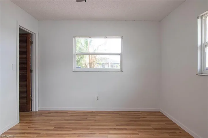 Unfurnished bedroom featuring light wood-style floors and a textured ceiling