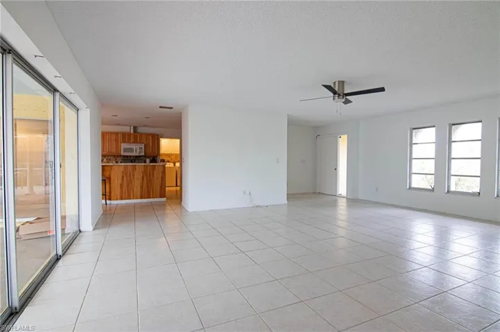 Unfurnished room with a ceiling fan, a textured ceiling, and light tile patterned floors