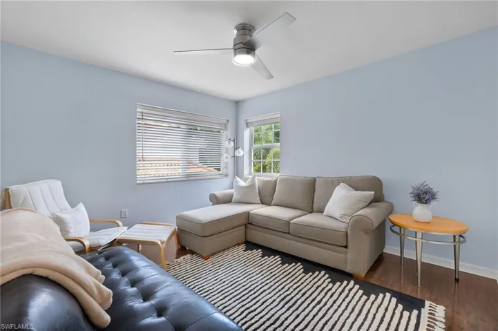 Living room with ceiling fan and hardwood / wood-style flooring