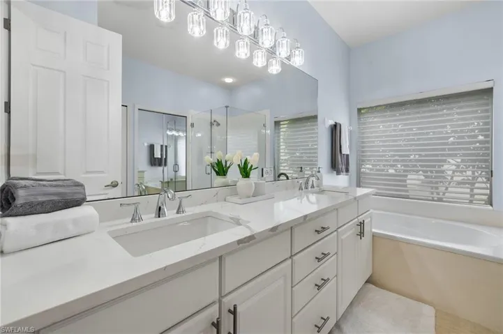 Bathroom with tile floors, independent shower and bath, oversized vanity, and double sink