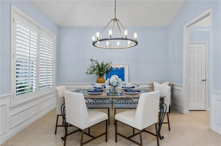Tiled dining space with an inviting chandelier and vaulted ceiling