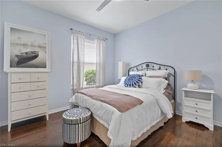 Bedroom with ceiling fan and dark wood-type flooring