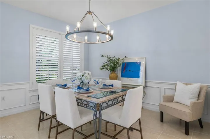 Dining room with an inviting chandelier and light tile flooring