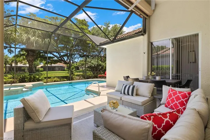 View of pool featuring glass enclosure, an outdoor living space, and a patio area
