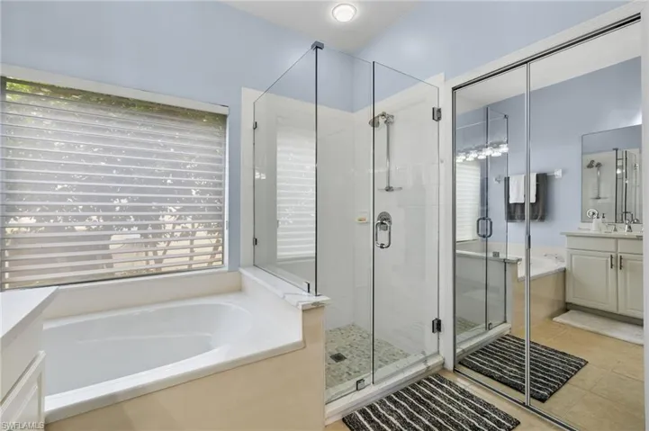 Bathroom with tile floors, separate shower and tub, and vanity