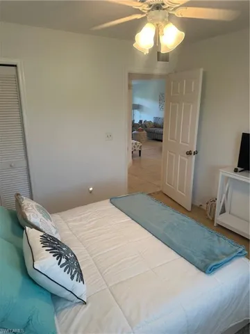Bedroom featuring tile patterned floors, a closet, and ceiling fan