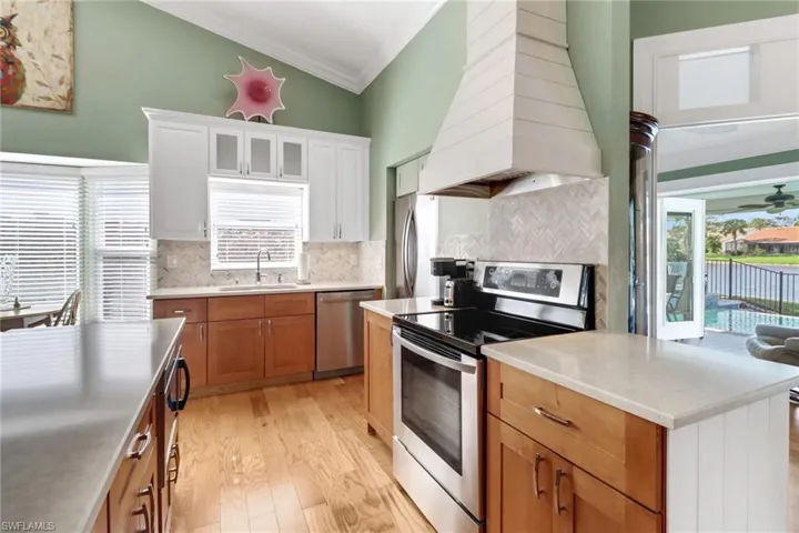 Kitchen featuring a wealth of natural light, stainless steel appliances, sink, light hardwood / wood-style flooring, and white cabinets