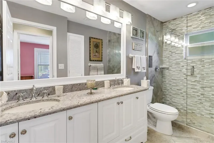 Bathroom with tile patterned floors, vanity, toilet, and walk in shower