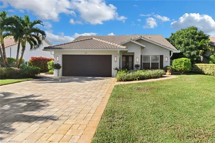 Mediterranean / spanish home with a garage and a front yard
