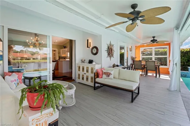 Sunroom featuring ceiling fan with notable chandelier and vaulted ceiling