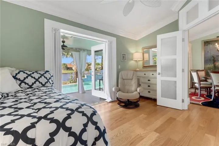 Bedroom featuring multiple windows, crown molding, and light hardwood / wood-style floors