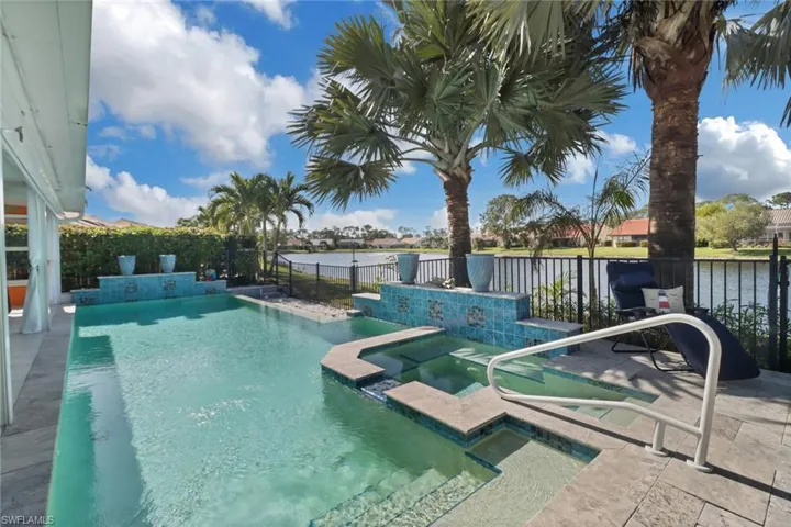 View of pool featuring an in ground hot tub and a water view