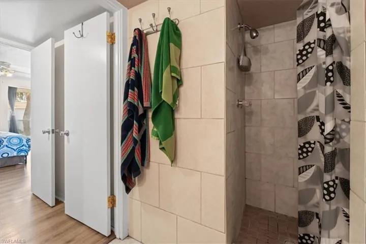Ensuite bathroom with a tile shower and wood finished floors
