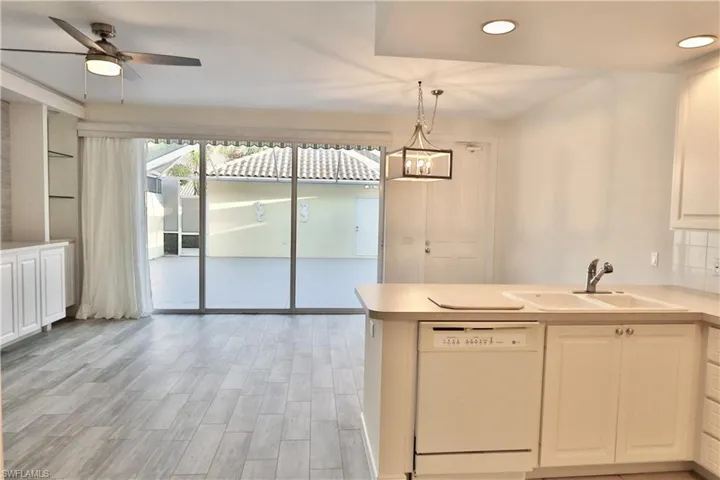 Spacious interior featuring wood-finish flooring, a contemporary ceiling fan, and sliding glass doors opening to a private patio
