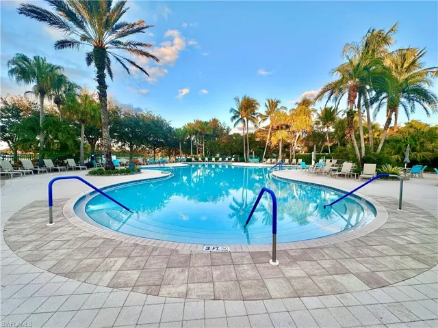 Resort-style swimming pool featuring a curved design and integrated steps
