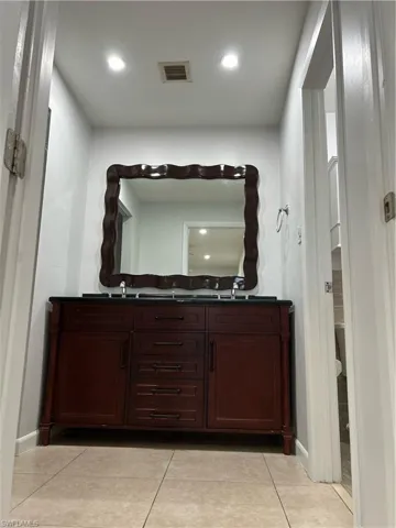 Bathroom featuring tile flooring and double sink vanity