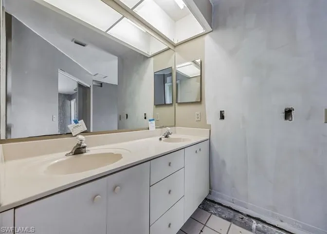 Bathroom with tile flooring, large vanity, and double sink