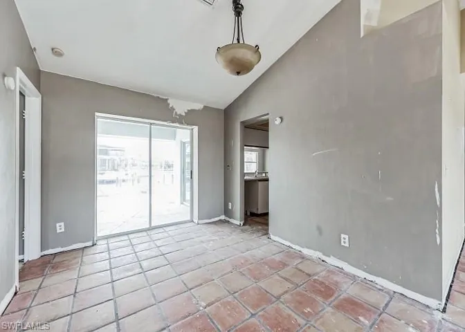 Tiled empty room with vaulted ceiling