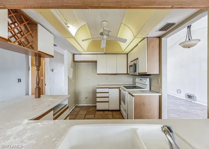 Kitchen featuring white cabinetry, light tile flooring, white electric range, and ceiling fan