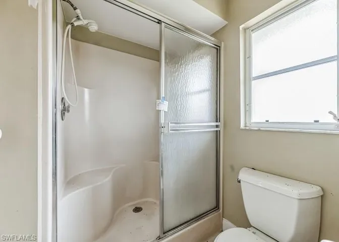 Bathroom with a shower with door and toilet