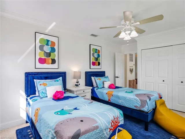 Bedroom featuring ornamental molding, ceiling fan, and a closet