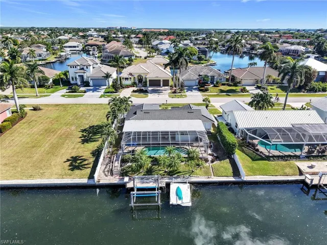 Aerial perspective of suburban area featuring a nearby body of water