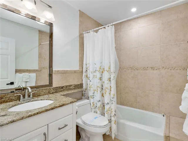 Bathroom featuring vanity and shower / tub combo with curtain