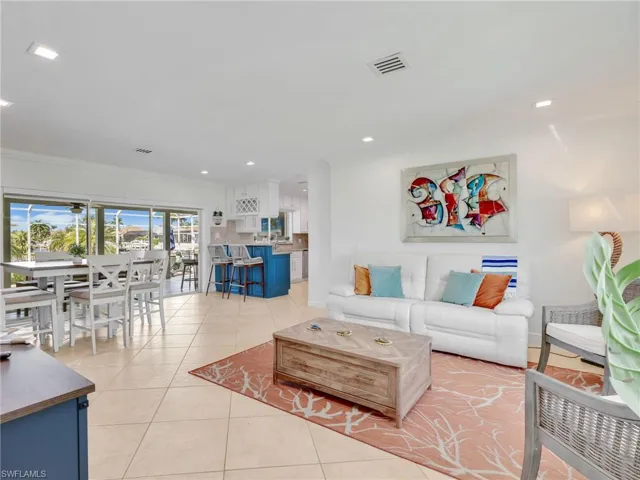 Living area featuring light tile patterned floors, crown molding, and recessed lighting