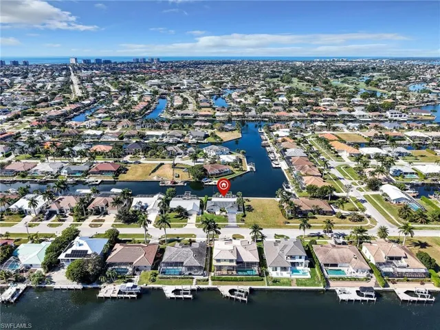 Aerial view of property and surrounding area featuring a nearby body of water and nearby suburban area