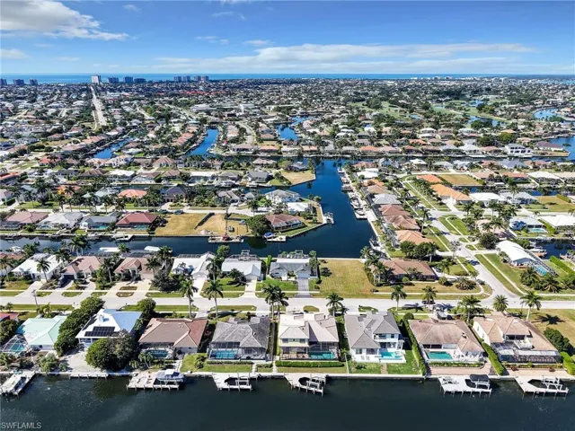 Aerial view of property and surrounding area with a large body of water and nearby suburban area