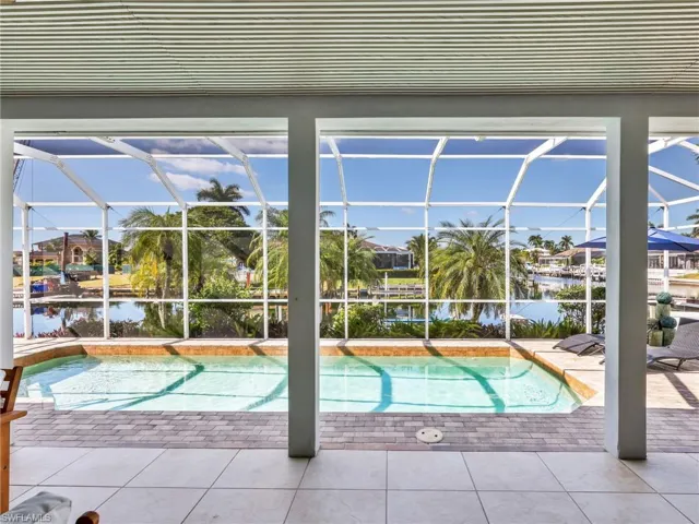 Swimming pool with a water view, a sunroom, and a patio area