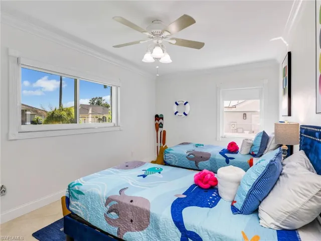 Bedroom featuring crown molding, tile patterned flooring, and a ceiling fan