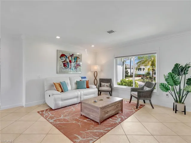 Living room featuring recessed lighting, crown molding, and light tile patterned floors