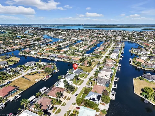 Aerial view of property's location featuring a nearby body of water and nearby suburban area