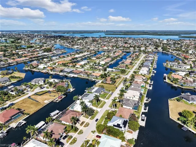 Aerial view of property and surrounding area with a large body of water and nearby suburban area