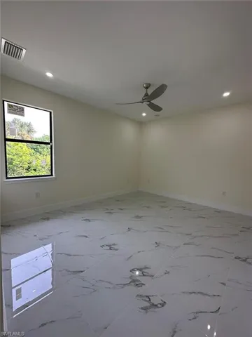Unfurnished room featuring ceiling fan, recessed lighting, and light marble finish floors