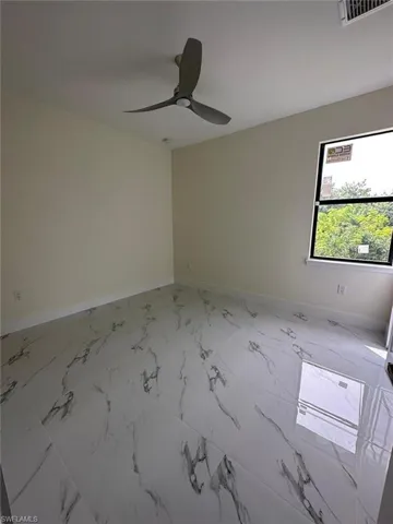 Empty room with ceiling fan and light marble finish flooring