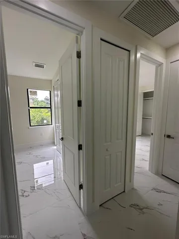 Hall featuring light marble finish flooring