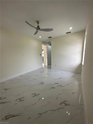 Unfurnished room with light marble finish flooring, recessed lighting, and a ceiling fan