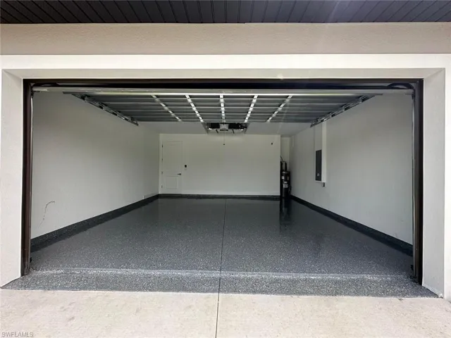 Garage featuring baseboards and electric panel