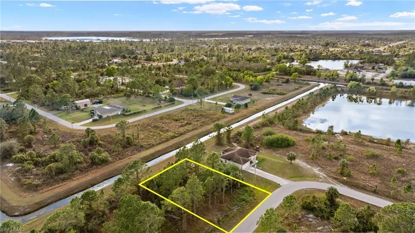 Birds eye view of property with a water view