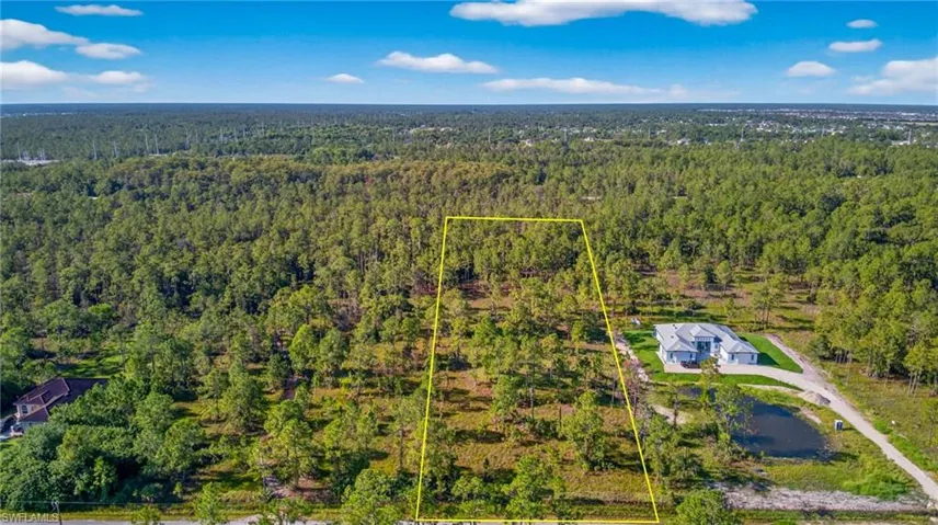 Aerial overview of property's location featuring property boundaries highlighted and a forest
