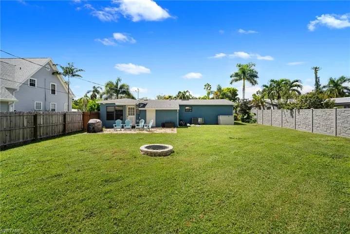 View of yard featuring a fire pit, cooling unit, and a patio