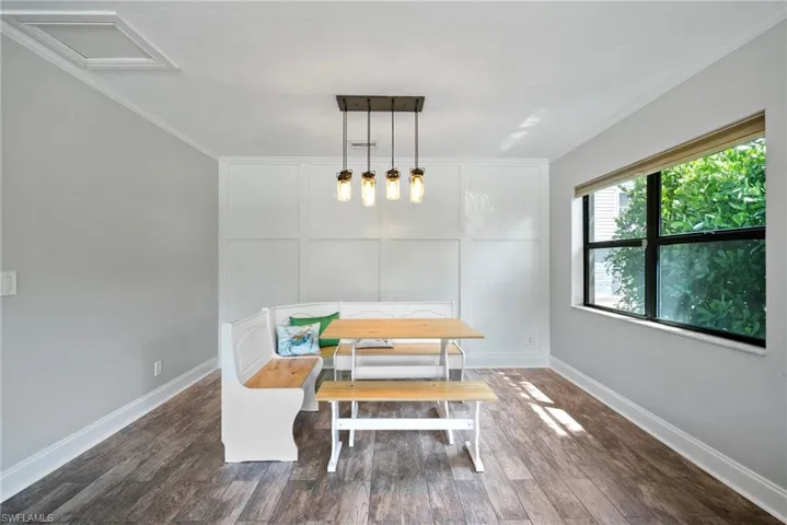 Dining space featuring ornamental molding and dark hardwood / wood-style flooring