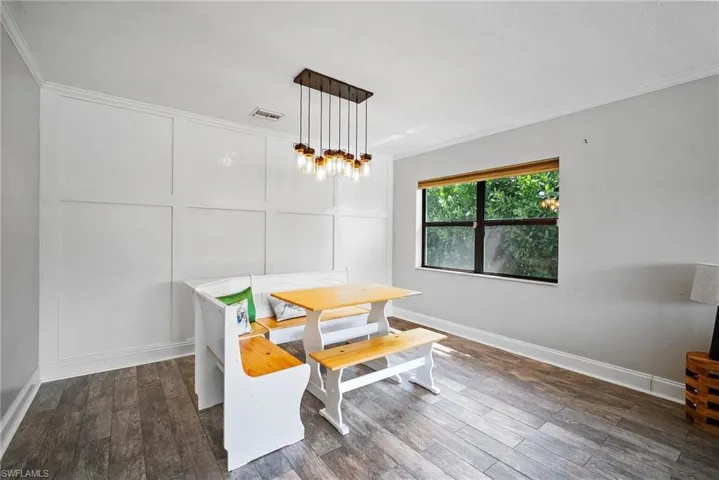 Dining space with crown molding and dark hardwood / wood-style flooring