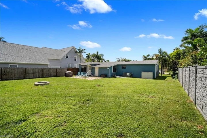 View of yard with an outdoor fire pit, cooling unit, and a patio