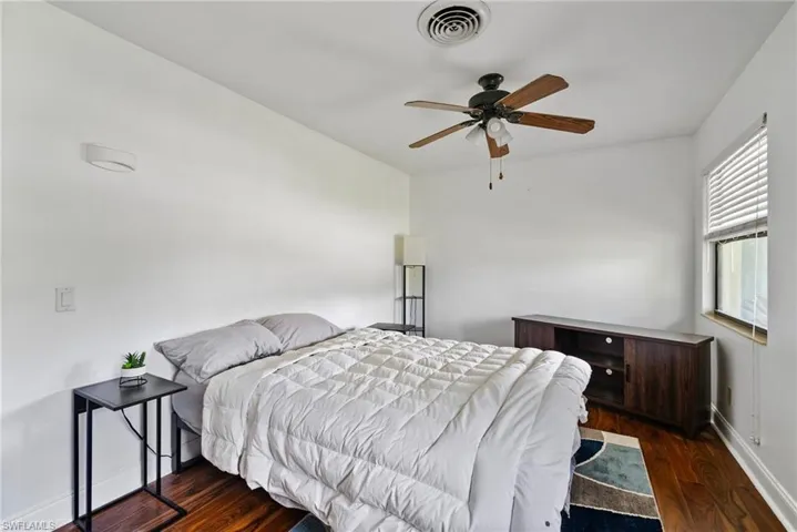 Bedroom with dark wood-type flooring and ceiling fan