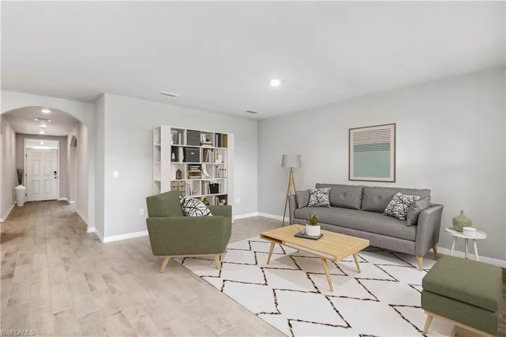 Virtually Staged-Living room featuring arched walkways, wood finished floors, and recessed lighting