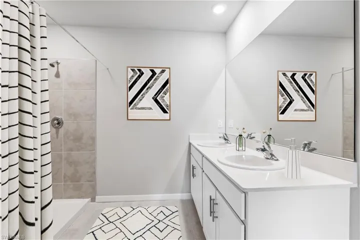 Virtually Staged-Bathroom featuring double vanity and a stall shower