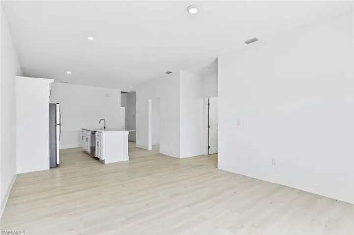 Bright and spacious living room flowing seamlessly into the stylish kitchen.